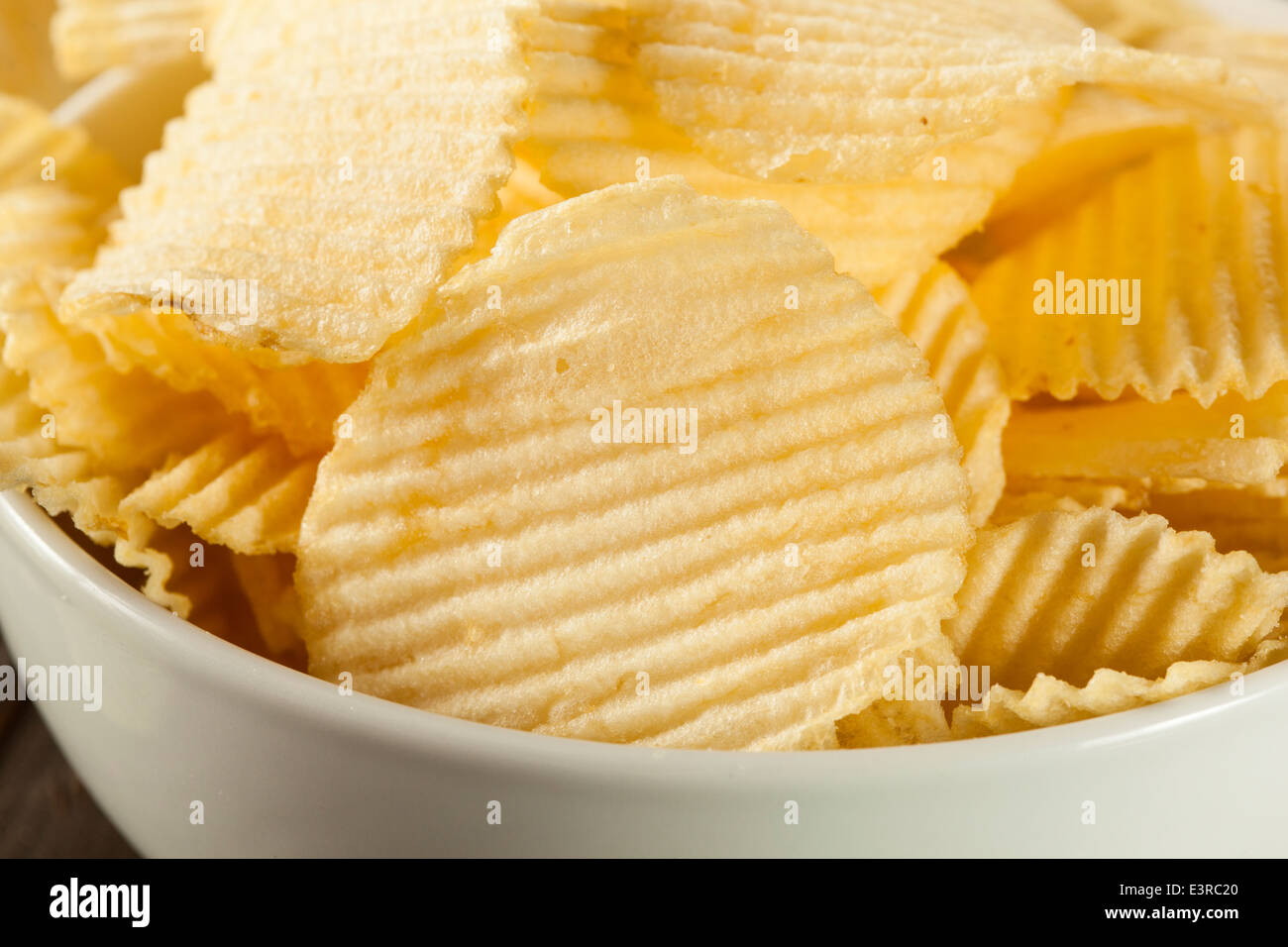 Ungesunde Crinkle geschnittene Kartoffelchips verzehrfertige Stockfoto