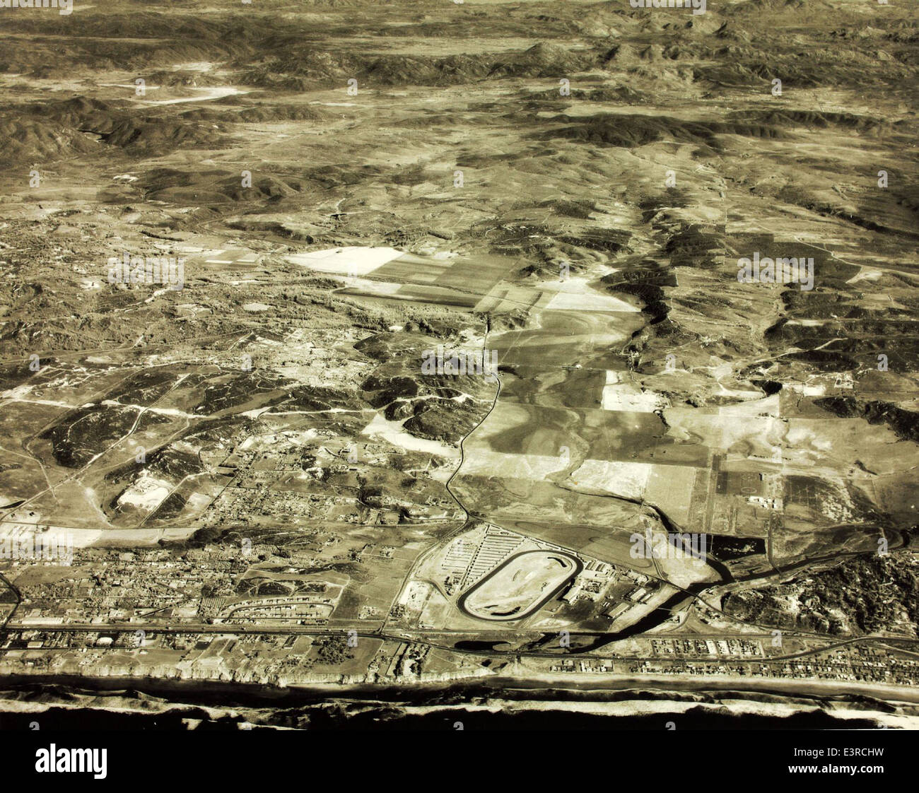 Ein Luftbild, das Howard Rozelle in den 1960er Jahren aufgenommen hat und das Gebiet von San Diego darstellt. Dieses Bild erfasst die Stadtlandschaft und die umliegenden Landschaften und spiegelt die Entwicklung und das Wachstum während dieses Jahrzehnts wider. Stockfoto