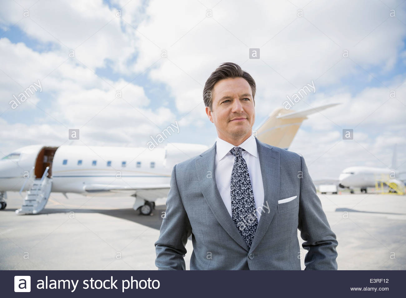 Geschäftsmann auf Asphalt mit corporate Jets Stockfoto