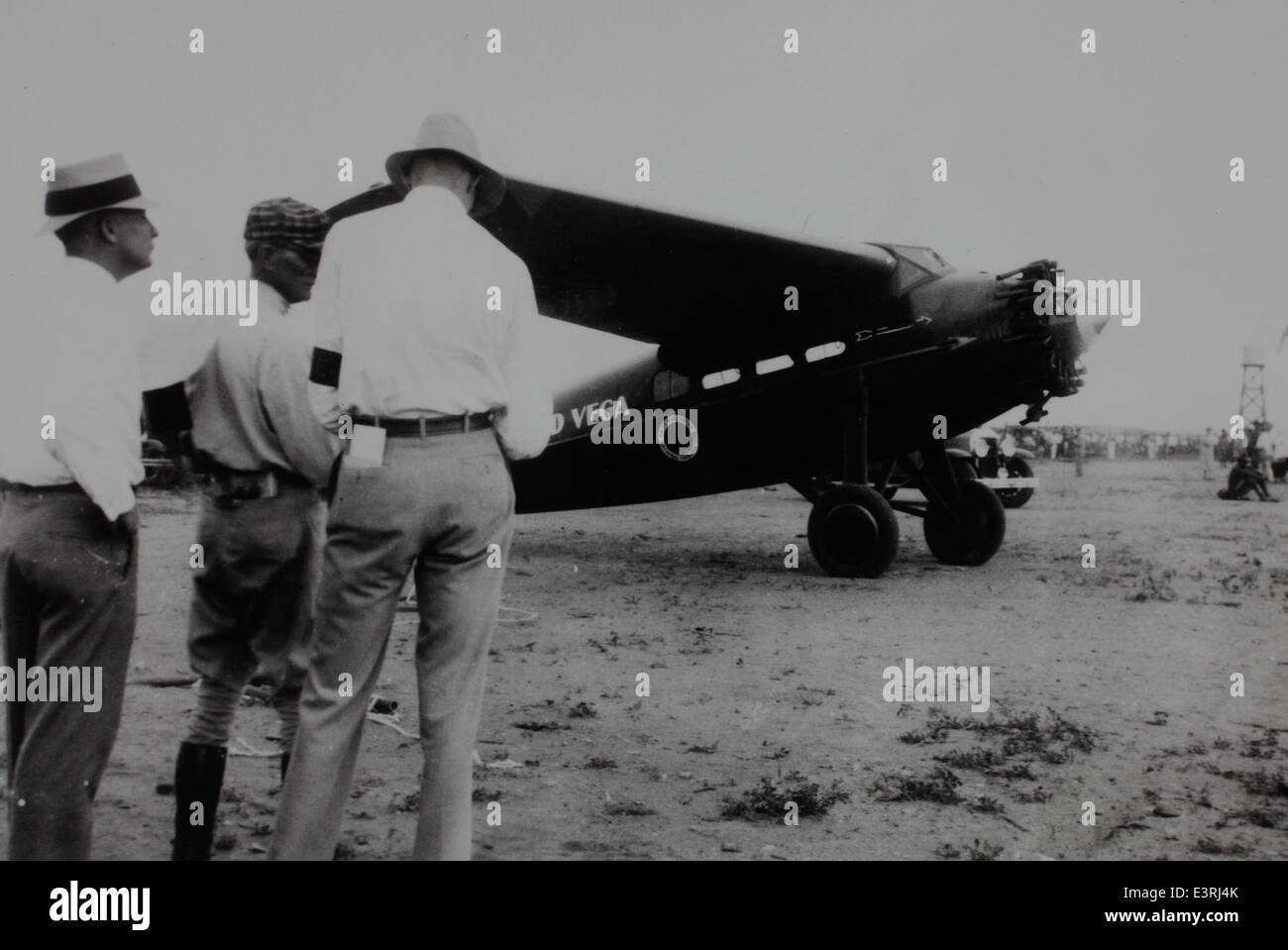 Dieses historische Bild zeigt eine Gruppe von Männern, die vor einem Flugzeug stehen. Das Foto fängt einen Moment in der Geschichte der Luftfahrt ein, bei dem möglicherweise Militärpersonal oder frühe Piloten während eines wichtigen Ereignisses oder Meilensteins in der Luftfahrt beteiligt sind. Stockfoto
