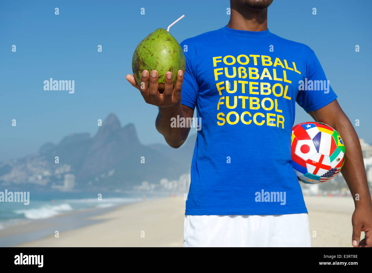 Brasilianischer Fußballspieler Fußball Hemd mit einer Kugel mit WM-Team-Flaggen und frische grüne Kokosnuss Stockfoto