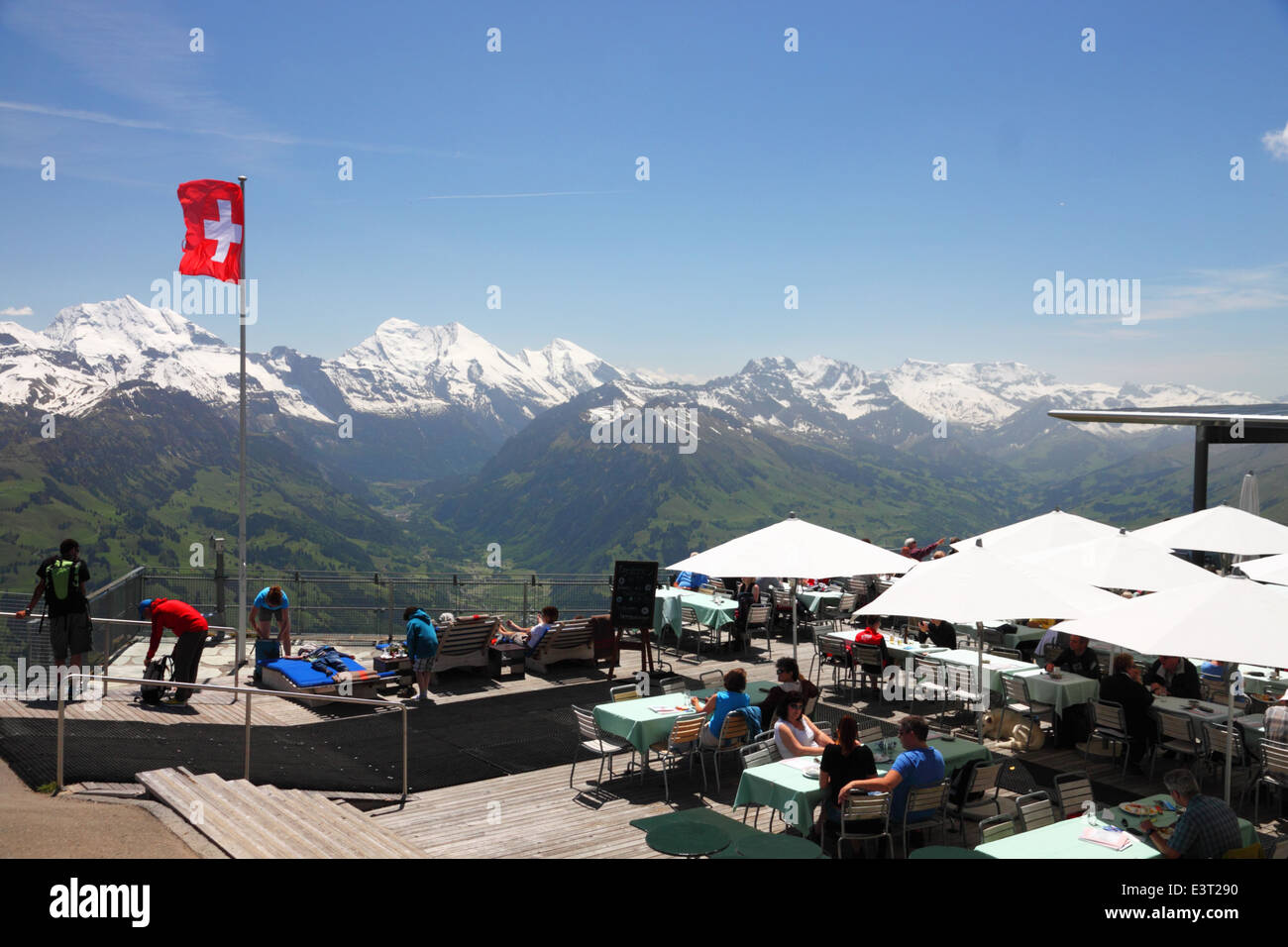 Ein Bergrestaurant mit schneebedeckten Gipfeln und einer Schweizer Flagge. Stockfoto