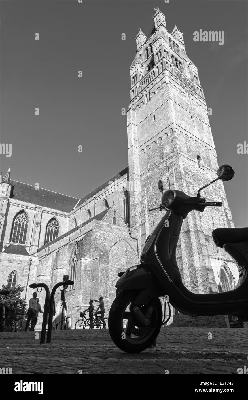 Brügge, Belgien - 13. Juni 2014: St. Salvator Kathedrale (Salvatorskerk) aus West und Silhouette des Scooter im Abendlicht. Stockfoto