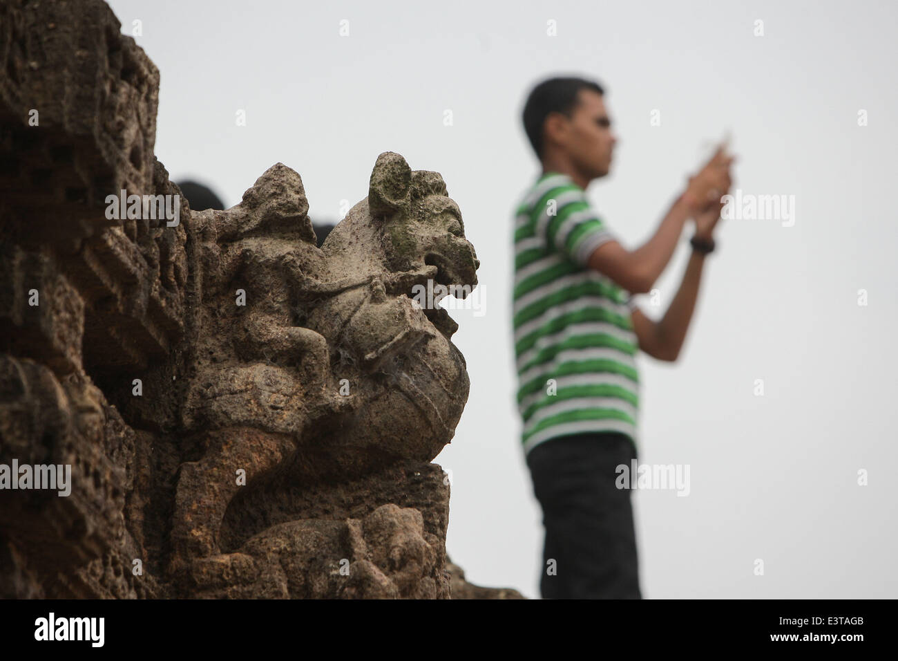 Odisha, Indien. 28. Juni 2014. Ein Tourist besucht der Sonnentempel in Konarak Odisha, Indien, 28. Juni 2014. An den Ufern der Bucht von Bengal, gebadet in den Strahlen der aufgehenden Sonne ist der Tempel in Konarak eine monumentale Darstellung der Sonnengott Surya Chariot. Seine 24 Räder sind mit symbolischen Motiven dekoriert, und es wird geführt von einem Team von sechs Pferden. Im 13. Jahrhundert erbaut, gehört zu Indiens berühmteste Brahman Heiligtümer. Der Sonnentempel von Konarak wurde 1984 von der UNESCO als Weltkulturerbe eingetragen. © Zheng Huansong/Xinhua/Alamy Live-Nachrichten Stockfoto