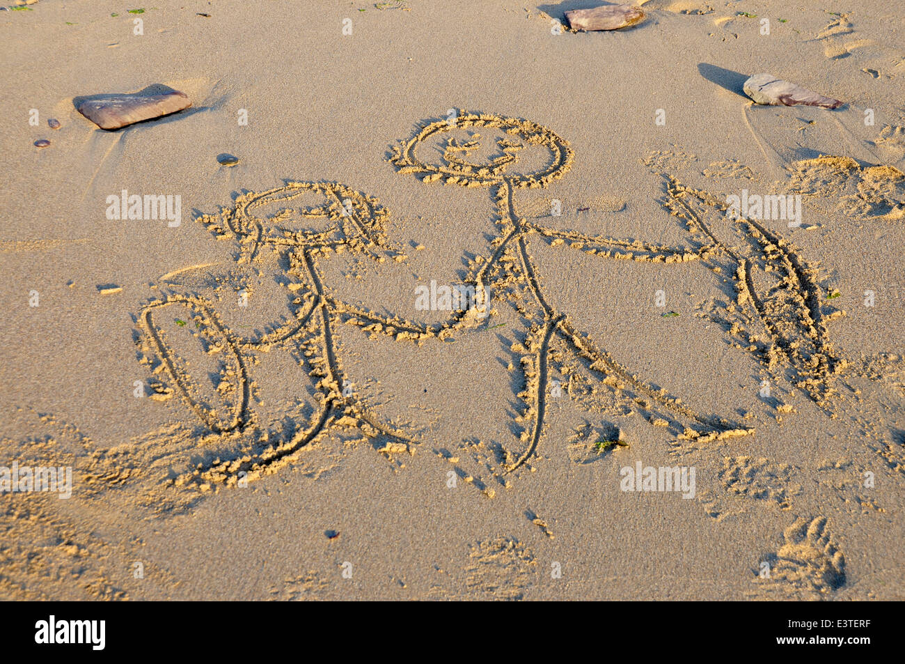 Einfache Gliederung Zeichnung geätzt in Sandstrand - bei Sonnenuntergang - zeigt paar Surfer - hand Stockfoto