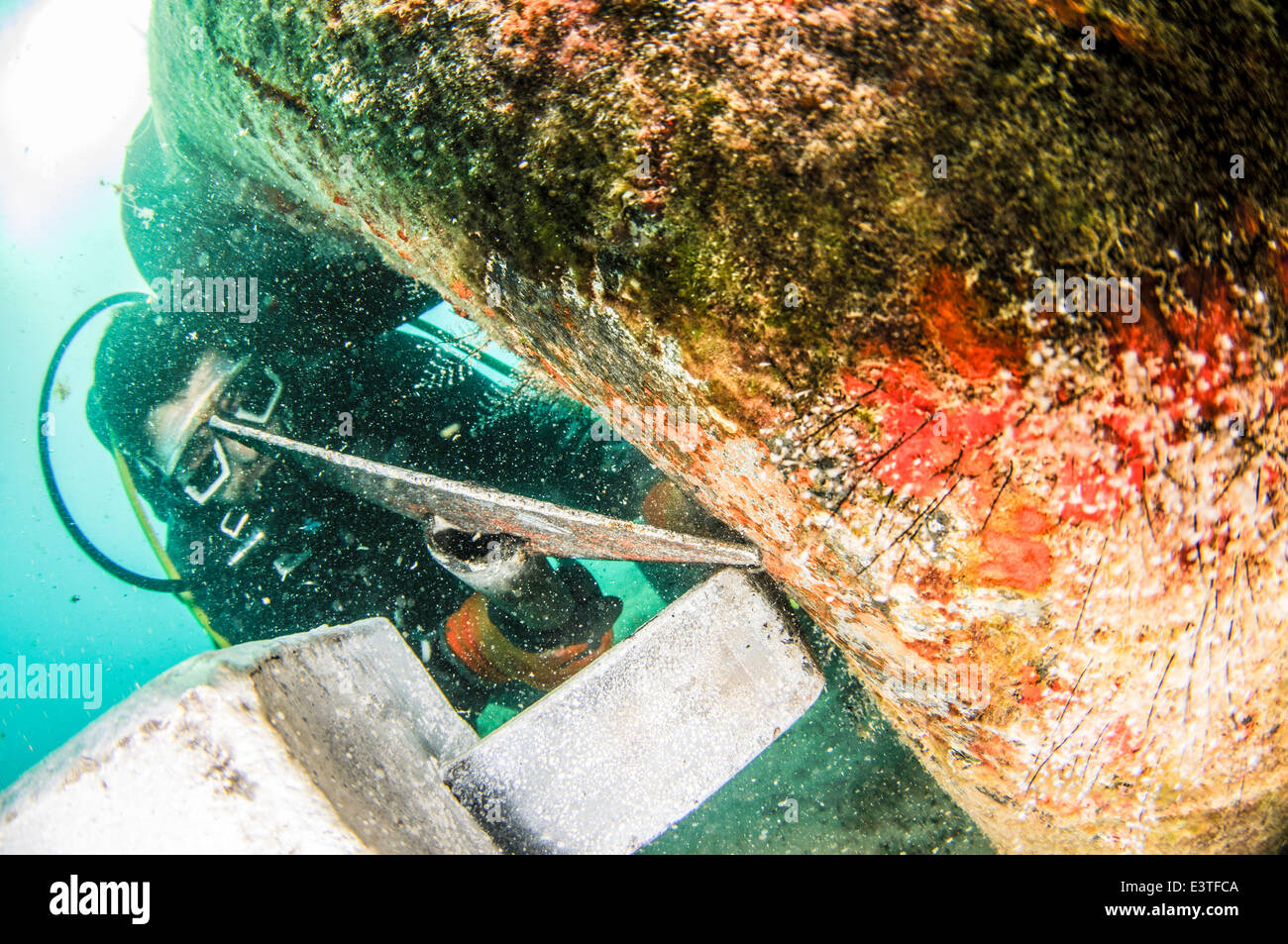 Kommerzielle Taucher legen eine Zinkanode auf eine Sole-Druckleitung aus einer Meerwasserentsalzungsanlage Stockfoto