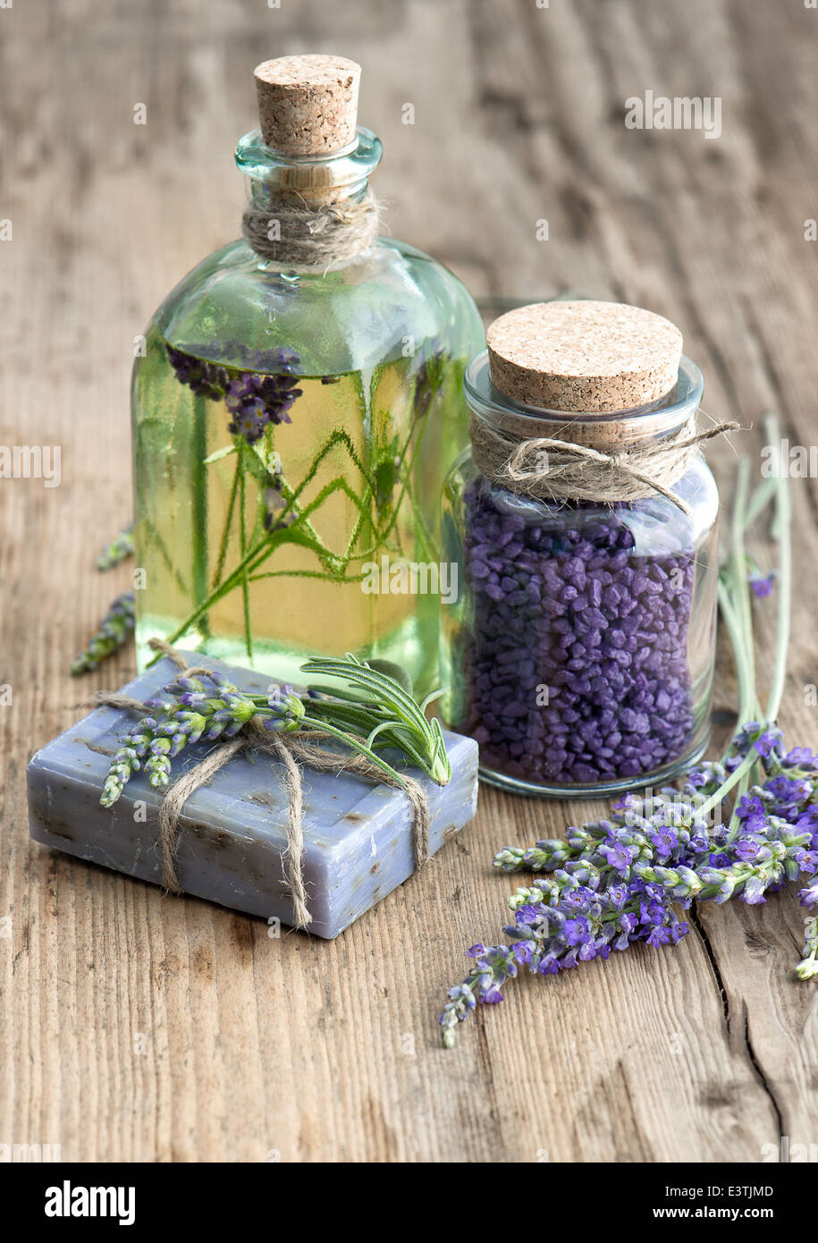Lavendel-Öl, pflanzliche Seife und Badesalz mit frischen Blumen auf hölzernen Hintergrund Stockfoto