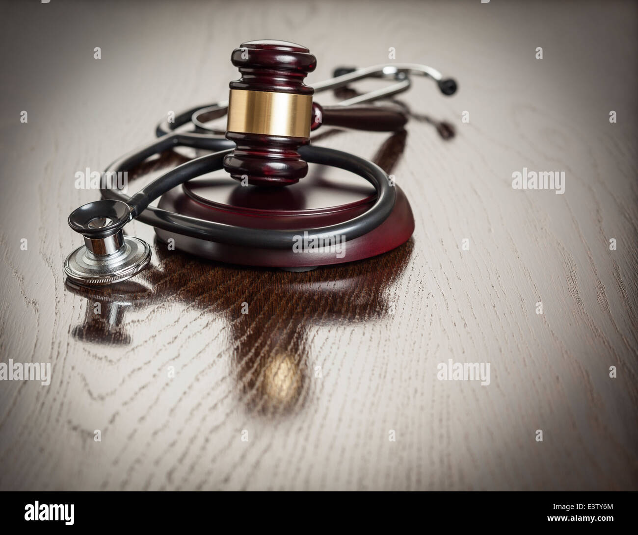 Hammer und Stethoskop auf reflektierende Holztisch. Stockfoto