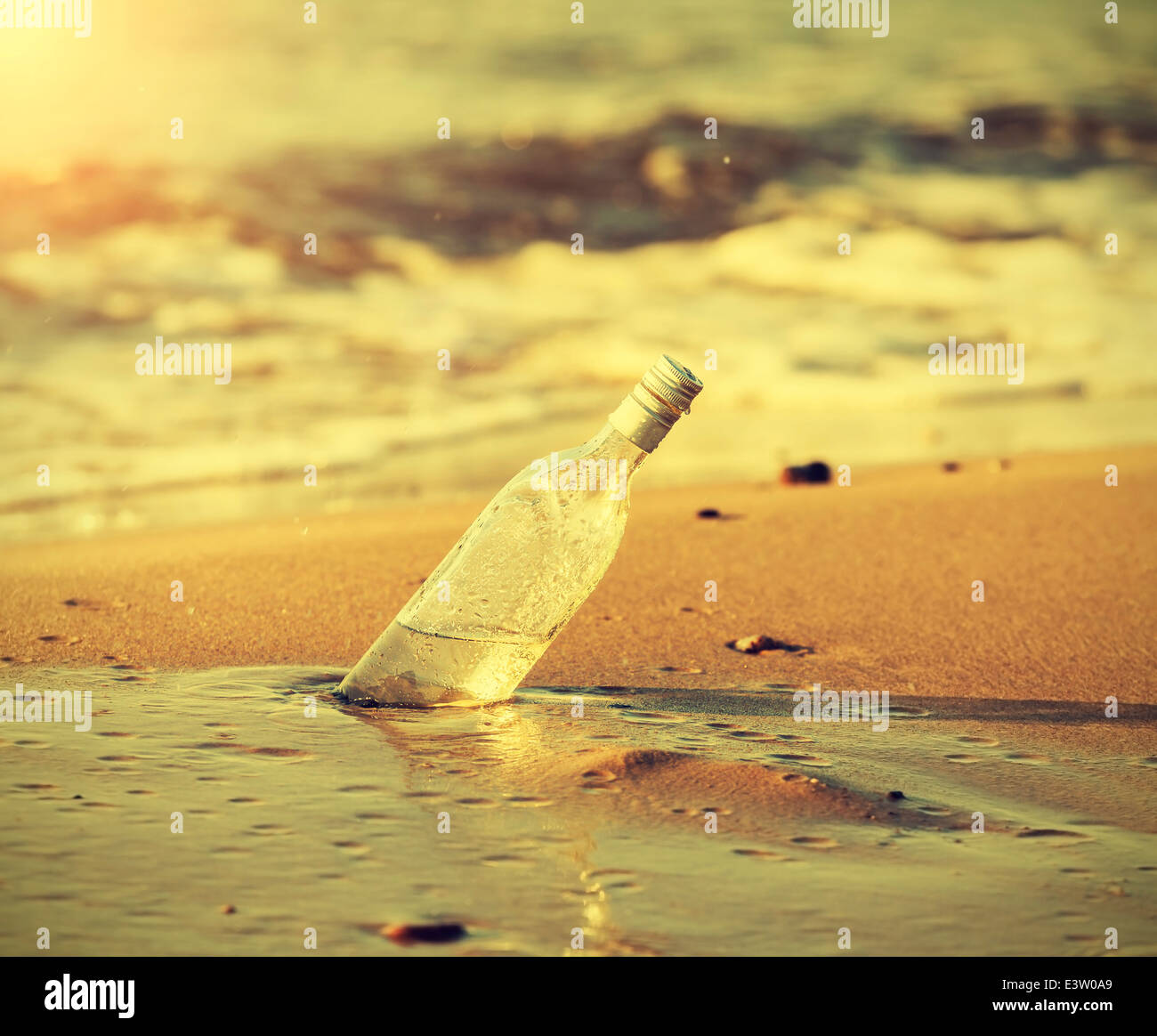 Flasche im Wasser bei Sonnenuntergang, Retro-Instagram-Vintage-Effekt. Stockfoto