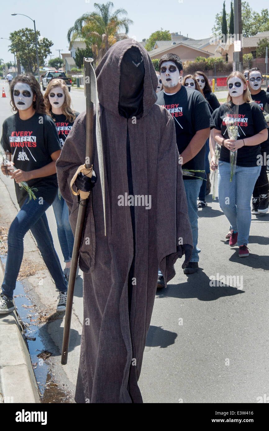 In "Grim Reaper" Kostümen gekleidet, beteiligen Schülerinnen und Schüler sich eine Dramatisierung von einem Autounfall, verursacht durch Trunkenheit am Steuer für die Erziehung der Mitschüler in Anaheim, CA. Hinweis groteske Make-up und "Every 15 Minutes"-t-Shirts von der Organisation sponsoring der Veranstaltung geliefert. Stockfoto