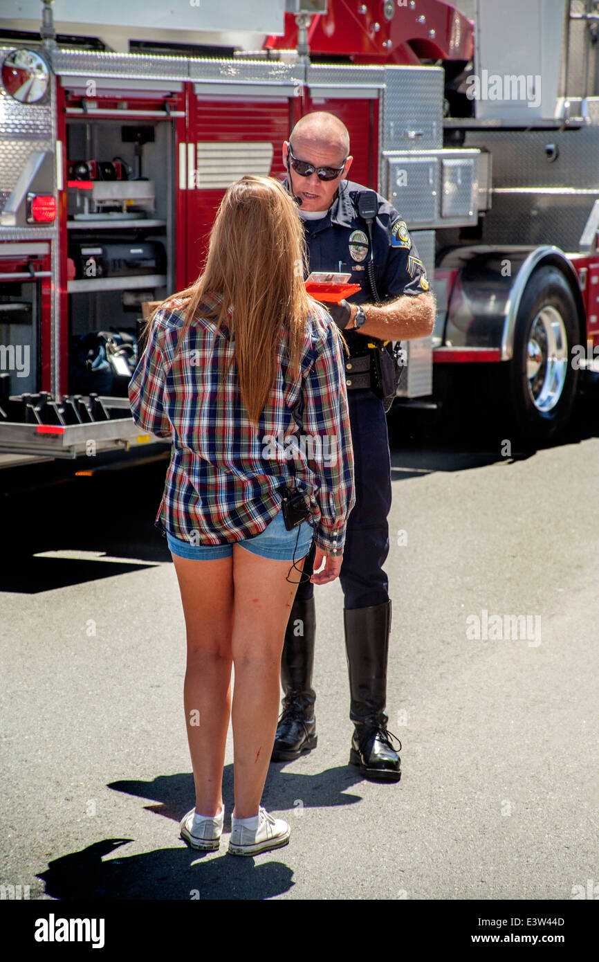 Eine freiwillige High-School-Mädchen spielt die Rolle eines Treibers von einem Polizisten in eine Dramatisierung der Gefahr der Trunkenheit am Steuer für die Erziehung der Mitschüler in Anaheim, CA. Hinweis Feuerwehrauto im Hintergrund verhört. Stockfoto