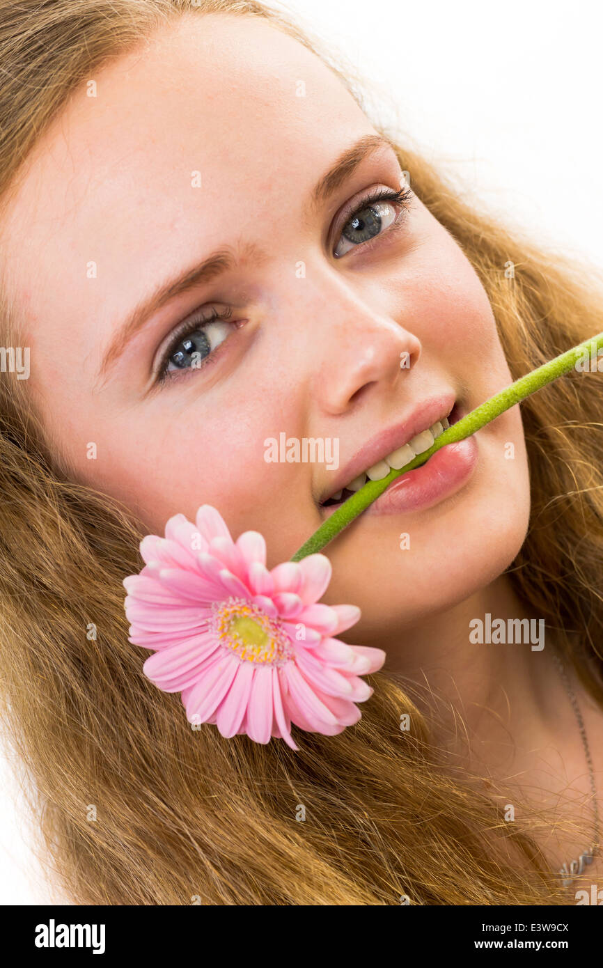 Gesicht eines Mädchens mit rosa Blume im Mund Stockfoto