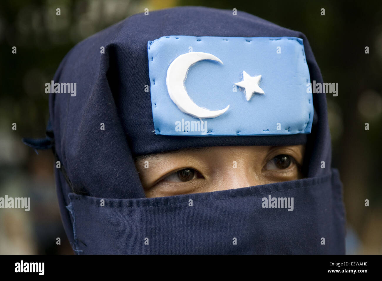 Eine verschleierte Anhänger der islamischen Bewegung Ostturkestan (TIM), der früher als die Islamische Bewegung Ostturkestan (ETIM) von Uigurischen Dschihadisten, die an einem Protest in der Uigurischen Autonomen Region Xinjiang gegründet bekannt. Western China Stockfoto