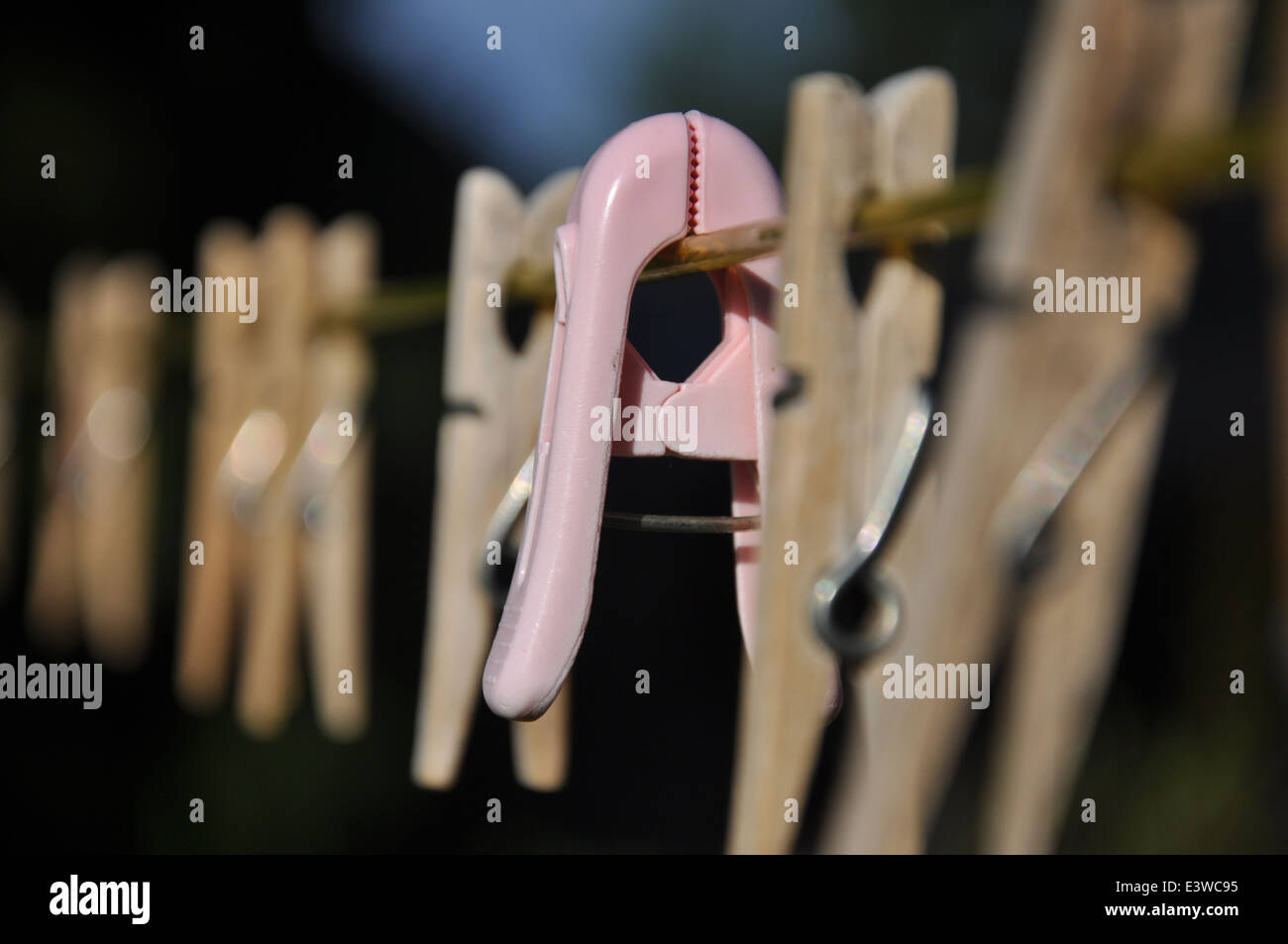 An einem sonnigen Tag hängen Holzkleider an einer Wäscheleine Stockfoto
