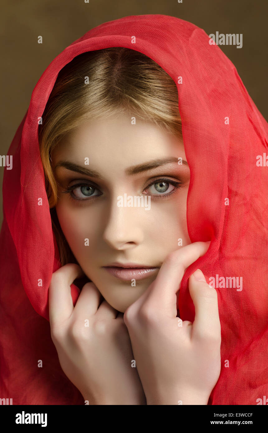 Schöne junge Frau bedeckt mit roten chiffon Schal Stockfoto