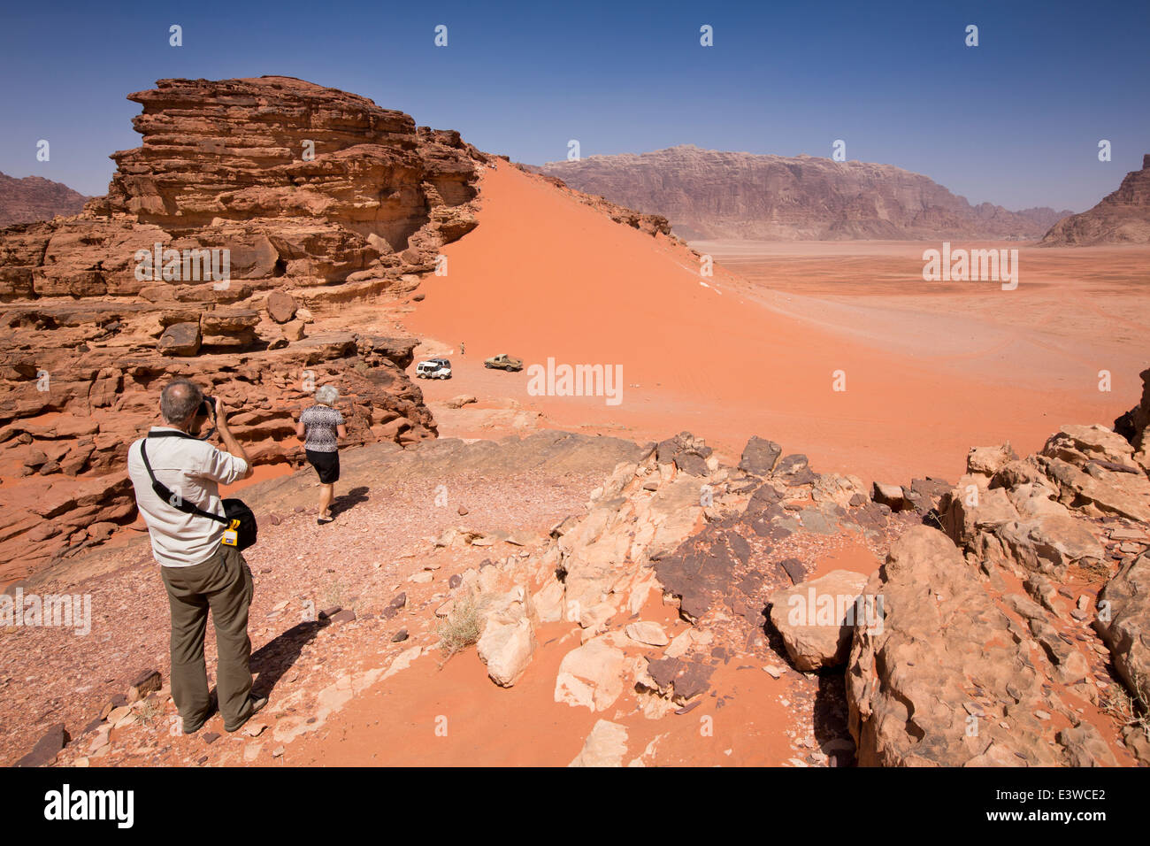 Jordan, Wadi Rum, westliche Touristen roten Sanddünen von Felsvorsprung anzeigen Stockfoto