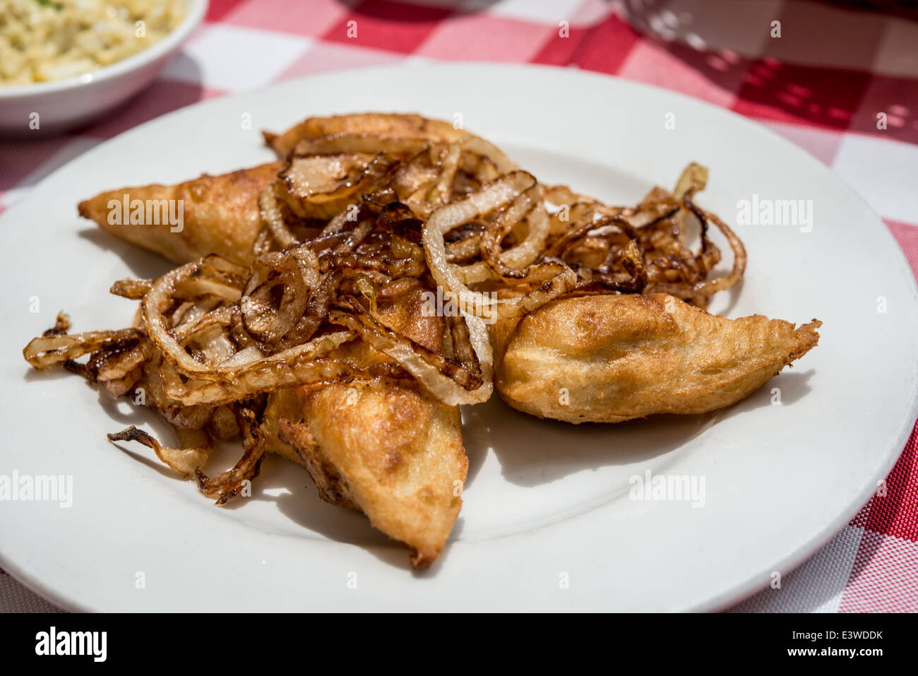 Fried Kreplach (jüdische Teigtaschen gefüllt mit Hackfleisch) serviert mit Zwiebeln Stockfoto