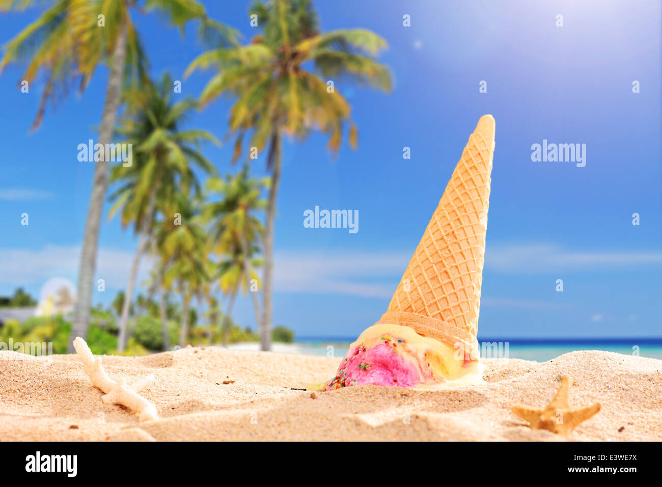 Ice Cream spritzte in den Sand am Strand an einem sonnigen Tag mit dem Fokus auf dem Eis Stockfoto