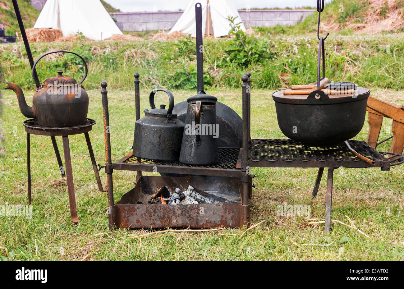 Camping am Lagerfeuer mit alten eisernen Töpfen Kochen Stockfoto