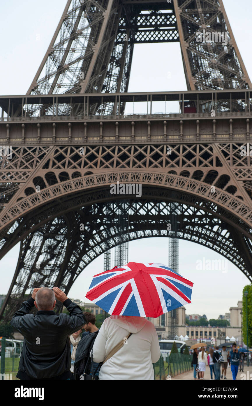 englische Touristen in Paris den Eiffelturm mit Union Jack Regenschirm im Regen fotografieren Stockfoto