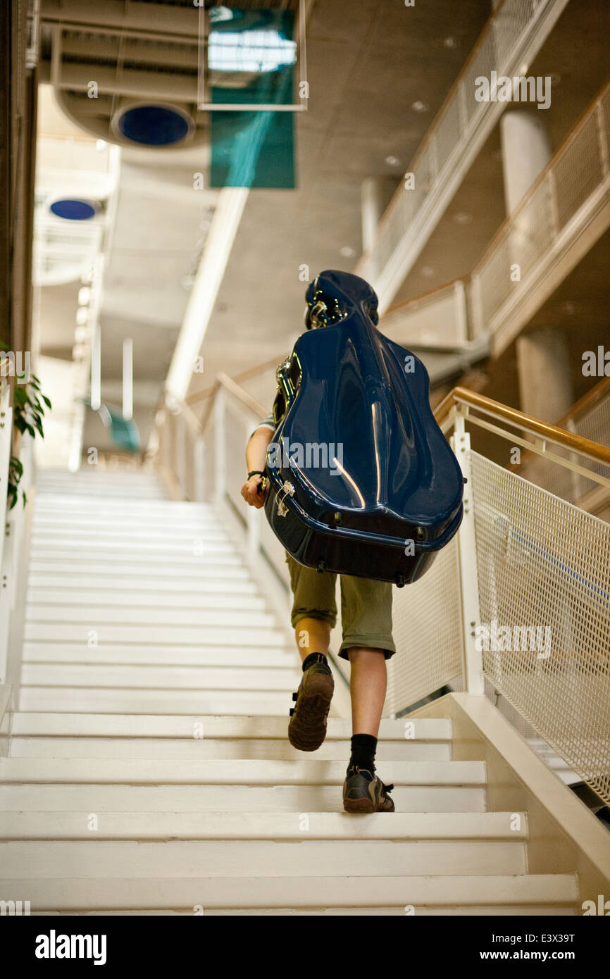Junge mit blauen Cellokasten Treppensteigen. Stockfoto