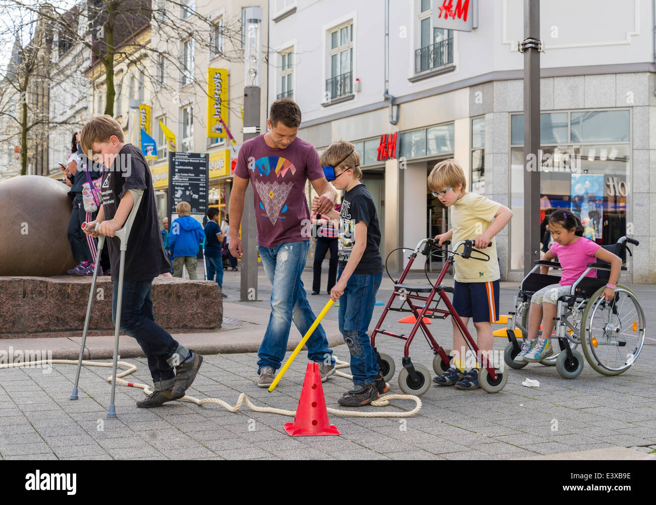 Kinder im Grundschulalter schauen Sie sich in einem Selbstversuch wie es auf irgendeine Art von Behinderung haben oder zu alt ist. Stockfoto