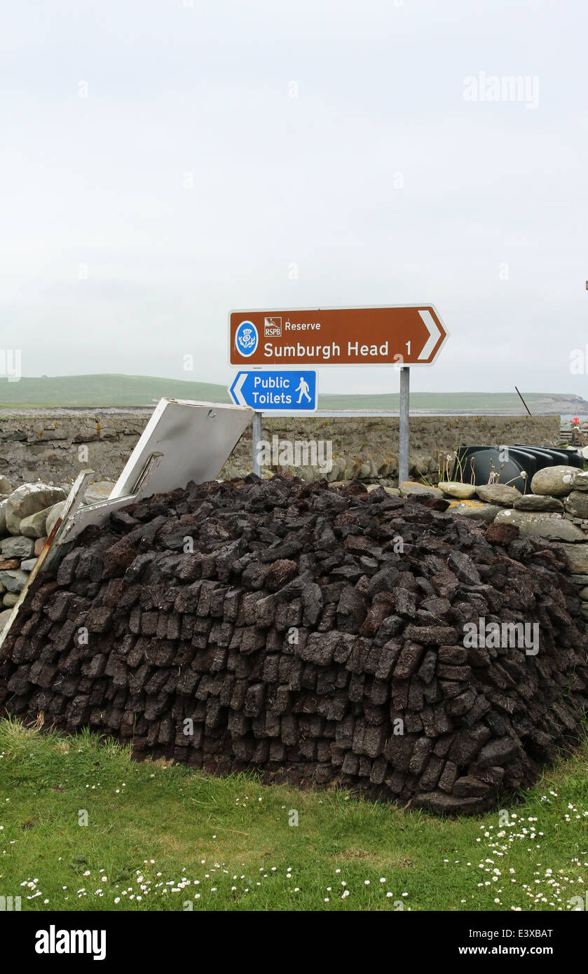 Haufen von Torf und Zeichen für Sumburgh Hotels Shetland Schottland Juni 2014 Stockfoto