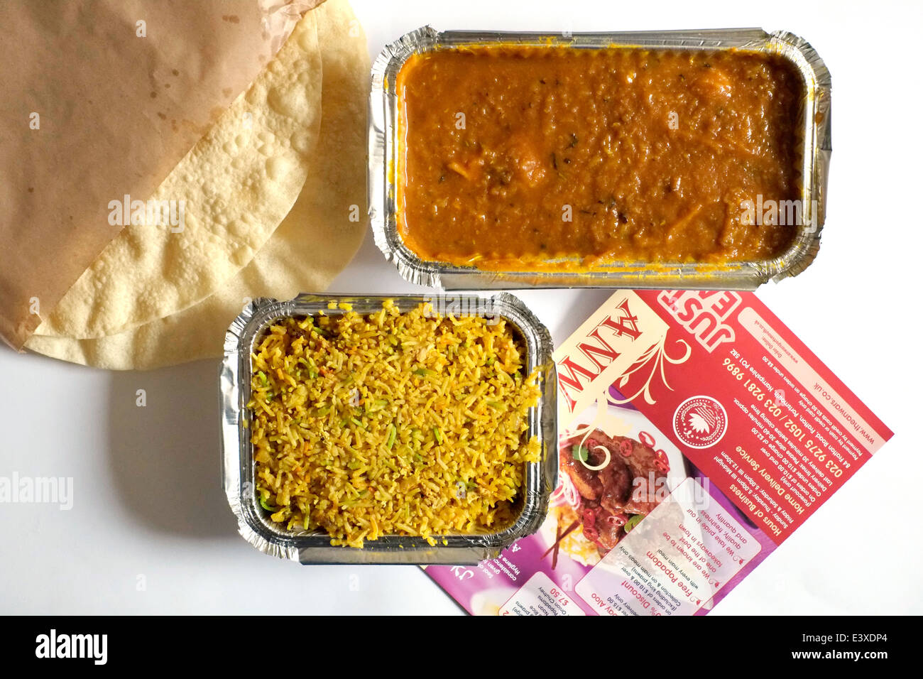 Mahlzeit zum Mitnehmen indisches Curry mit Reis Poppadoms und Menü Stockfoto