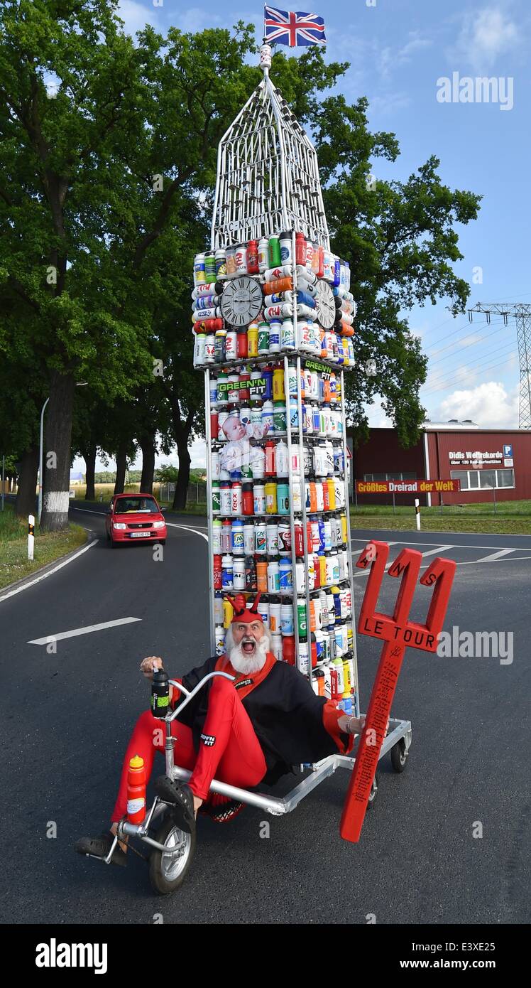 Storkow, Deutschland. 1. Juli 2014. Fahrrad-Designer Dieter "Didi" Senft ist in einem "Tour-Teufel" Kostüm gekleidet, als er seine neueste Kreation Fahrrad in Storkow, Deutschland, 1. Juli 2014 präsentiert. Er hat ein Fahrrad in der Form des Londoner Big Ben von 387 Trinkflaschen geschaffen. Der diesjährigen Tour de France startet am 5. Juli 2014. Senft arbeitet seit Jahren auf außergewöhnliche Motorrad Designs und zahlreiche Weltrekorde hält. Foto: PATRICK PLEUL/DPA/Alamy Live-Nachrichten Stockfoto