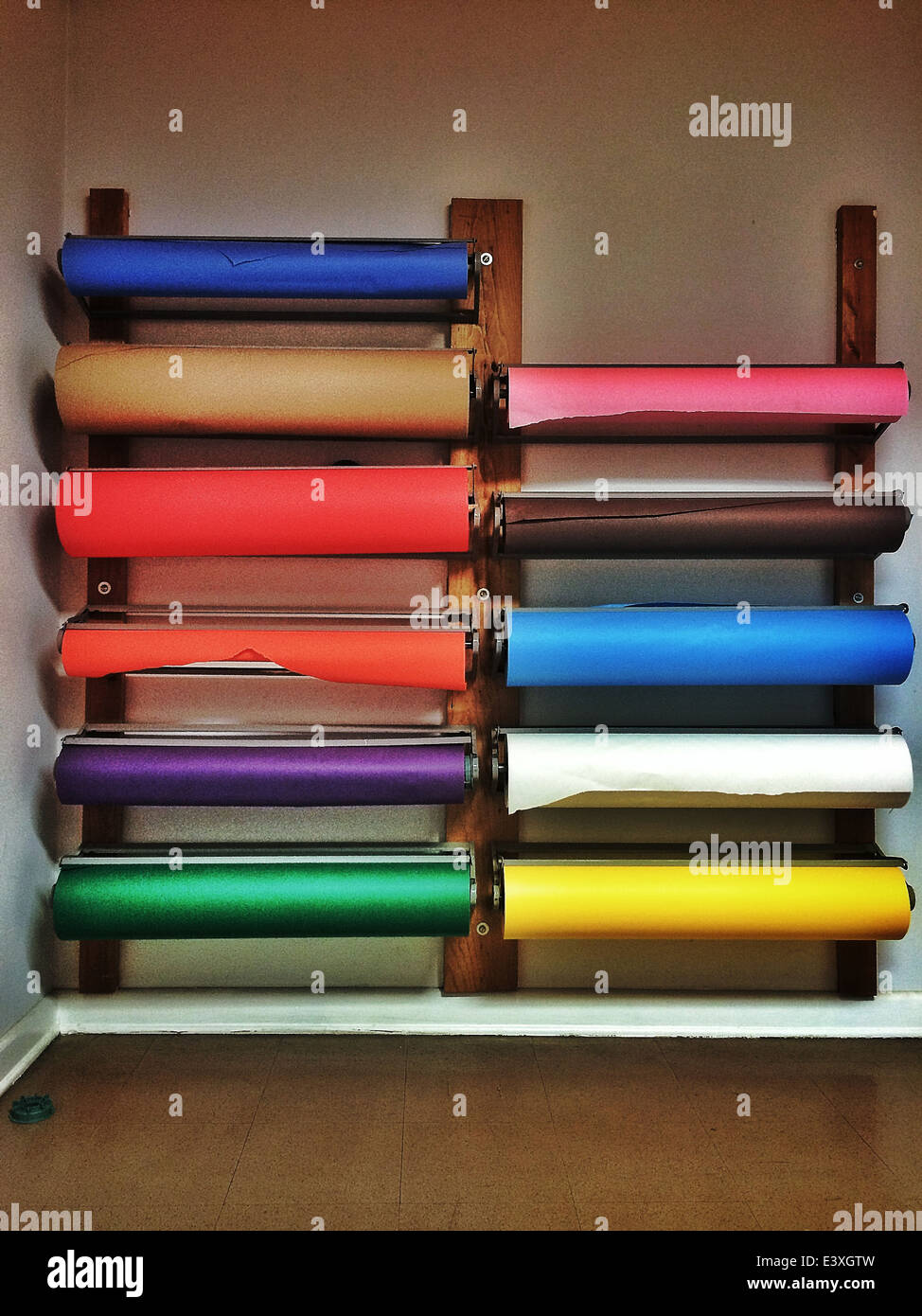 Bunte Papierrollen an der Wand montiert - Smartphone-aufgenommenes Stockfoto