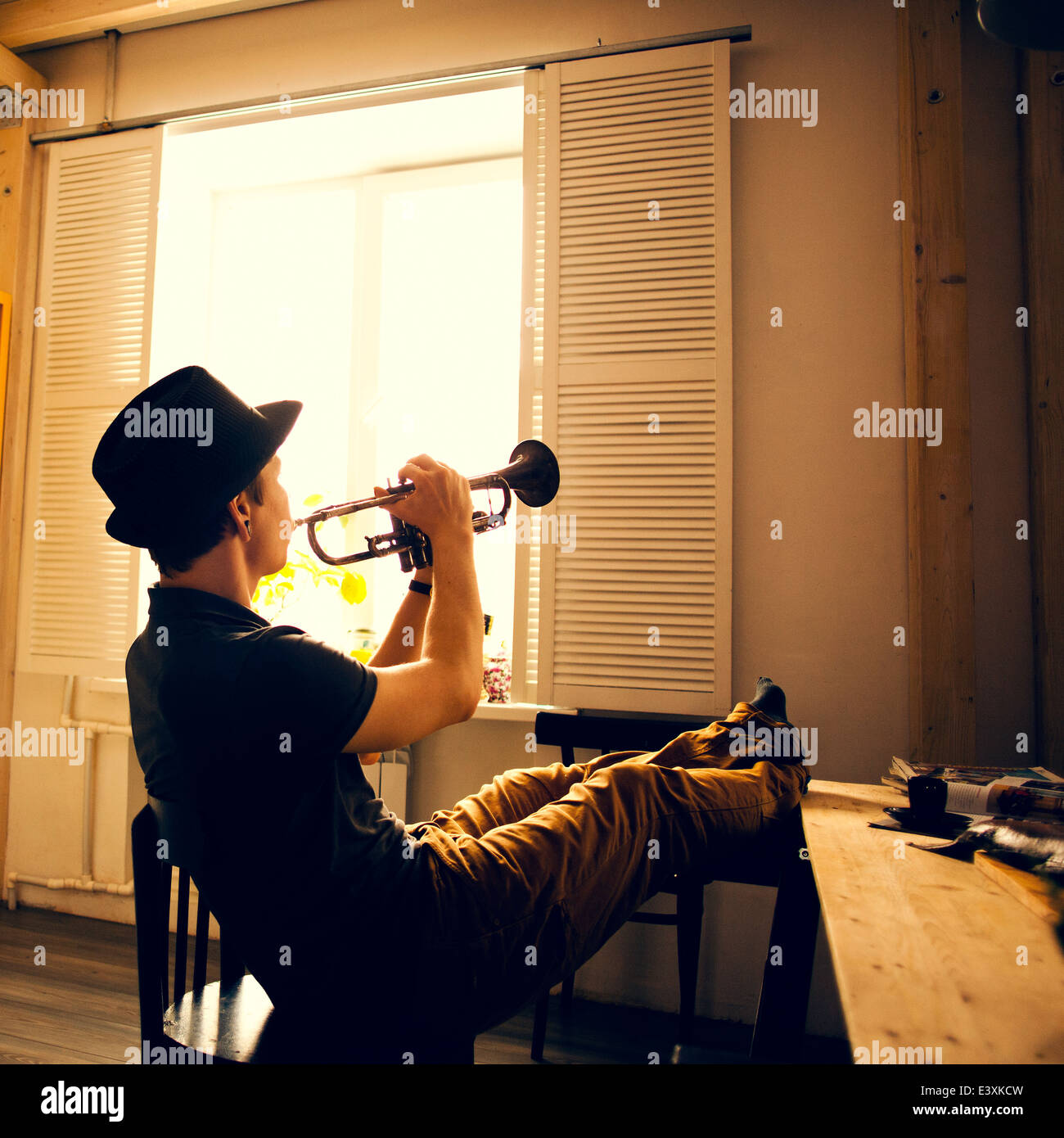 Kaukasischen Mann spielt Trompete in Küche Stockfoto