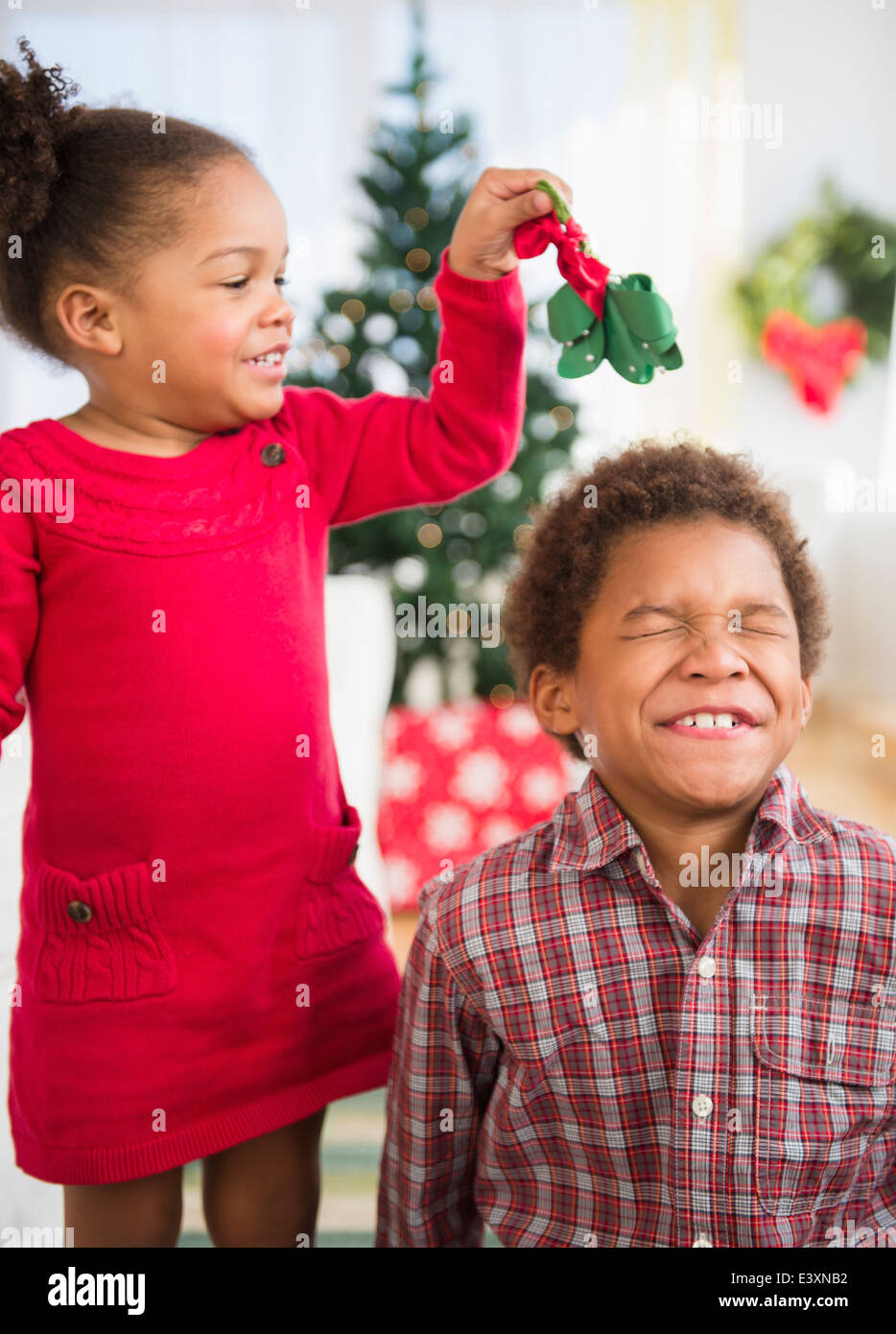 Schwarze Kinder spielen mit Mistel im Wohnzimmer Stockfoto