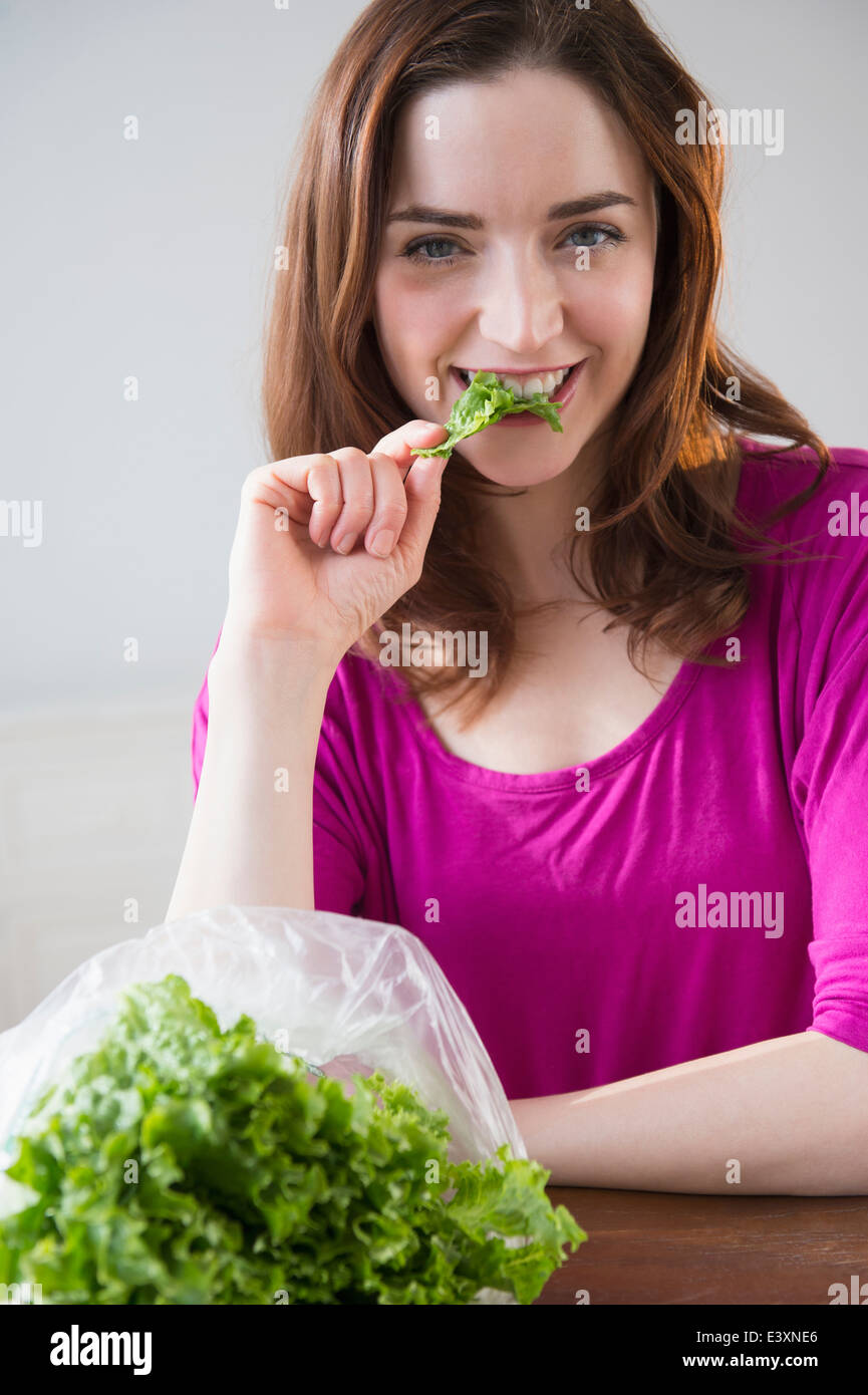 Frau Salat am Tisch essen Stockfoto