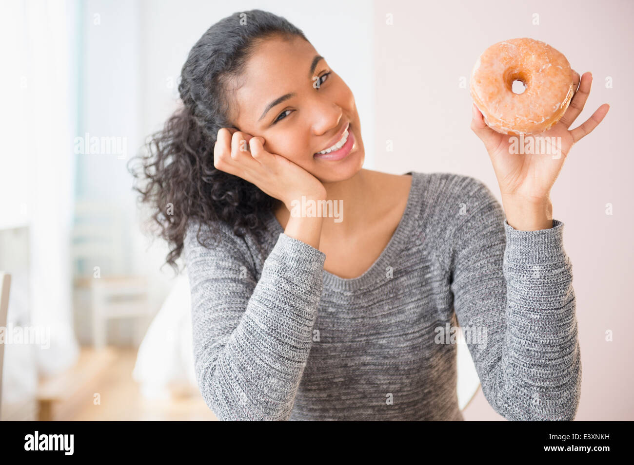 Gemischte Rassen Frau hält donut Stockfoto