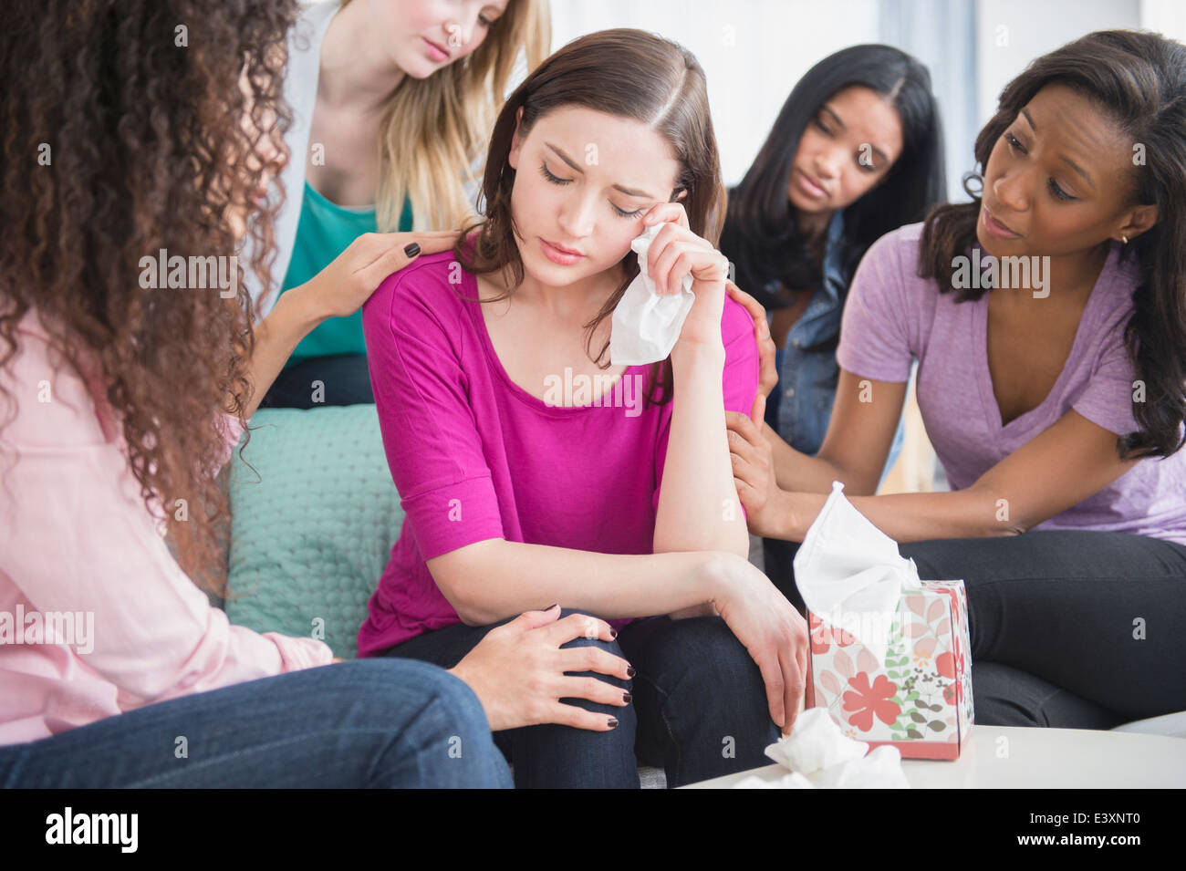 Weinende Frau umgeben von Freunden Stockfoto