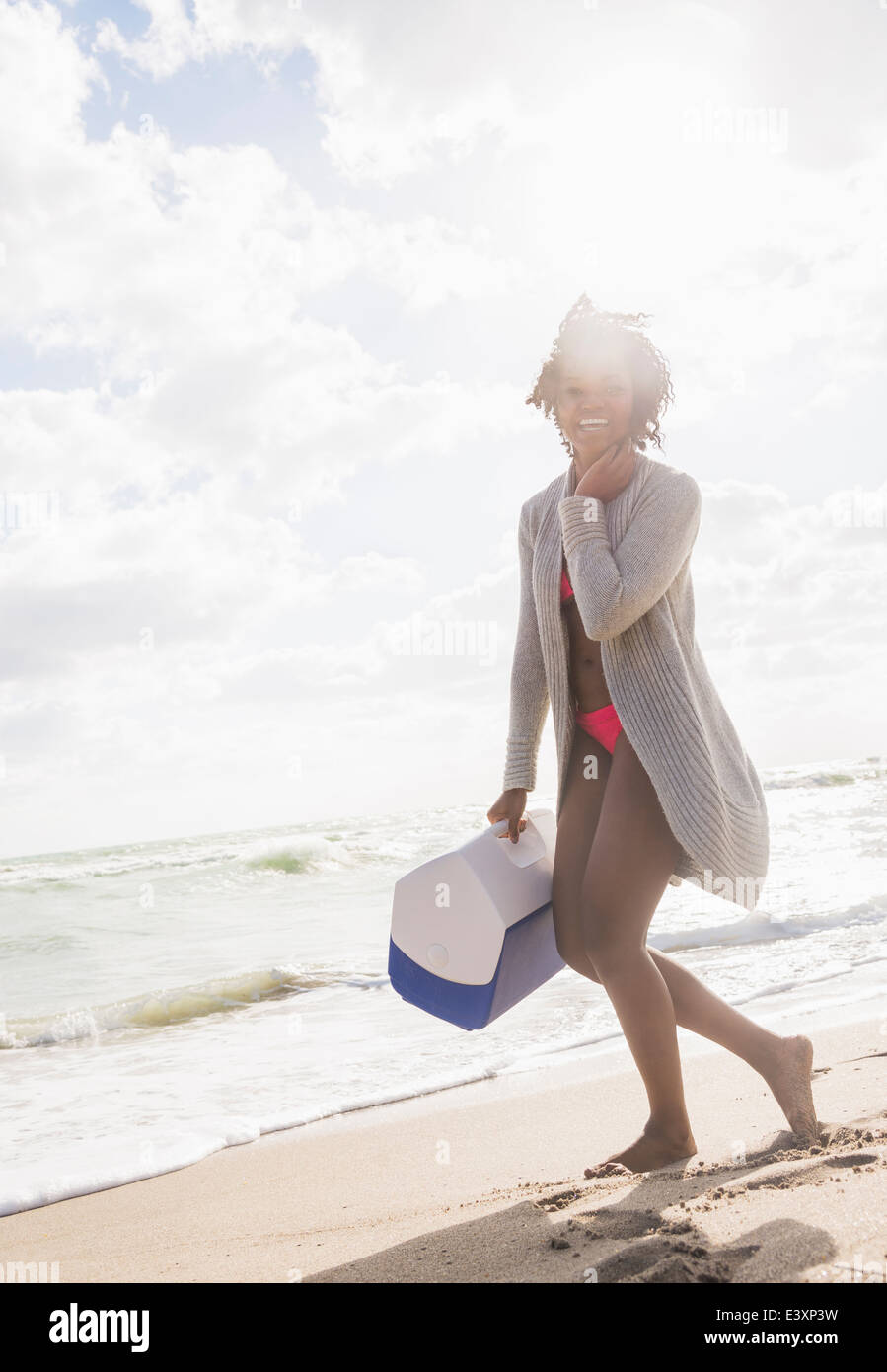 Afrikanische amerikanische Frau, die Kühler am Strand Stockfoto