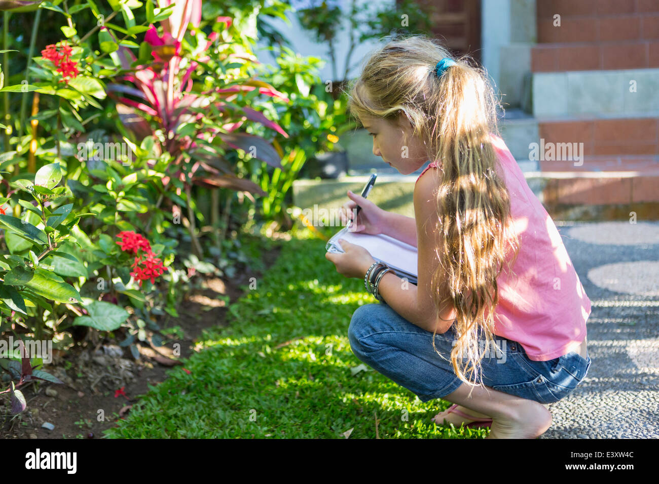 Kaukasische Mädchen untersuchen Tropenpflanzen Stockfoto
