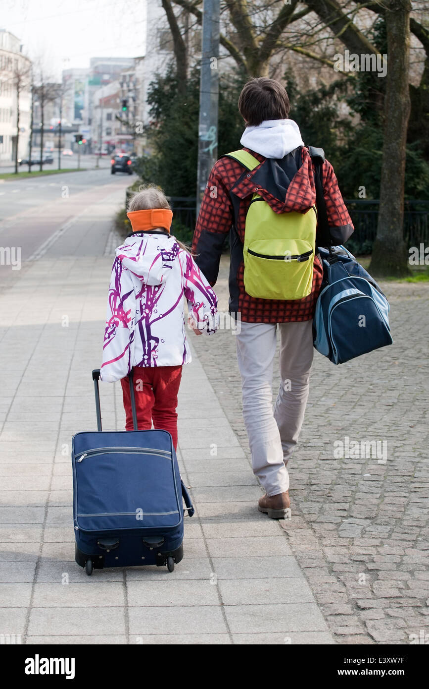 Bruder und Schwester zu Fuß mit Koffern entlang der Straße, Rückseite anzeigen Stockfoto