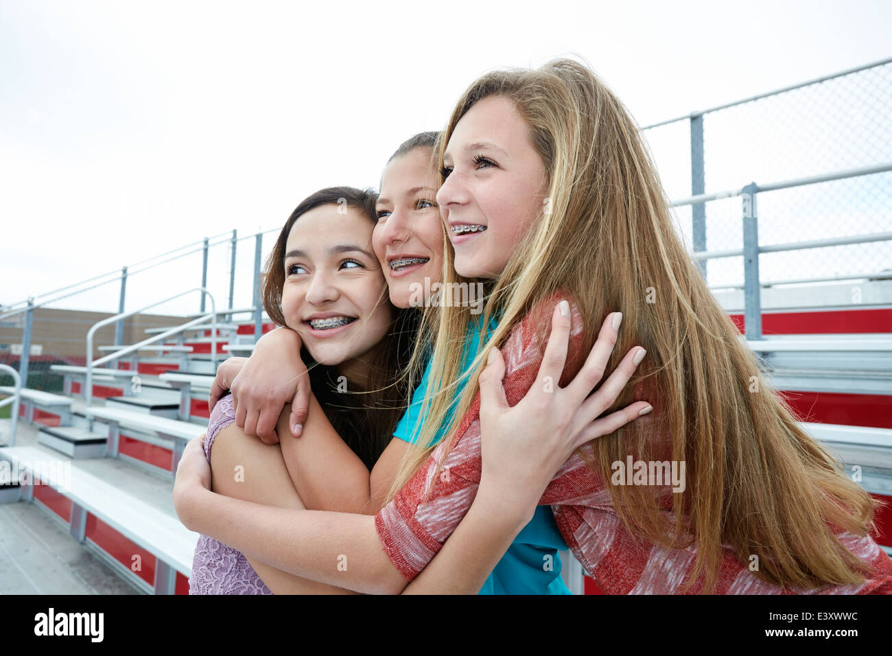 Mädchen im Teenageralter auf Tribüne umarmt Stockfoto