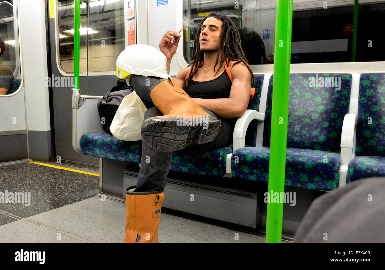 London, England, Vereinigtes Königreich. Mann Rauchen einer e-Zigarette auf einer u-Bahn Stockfoto