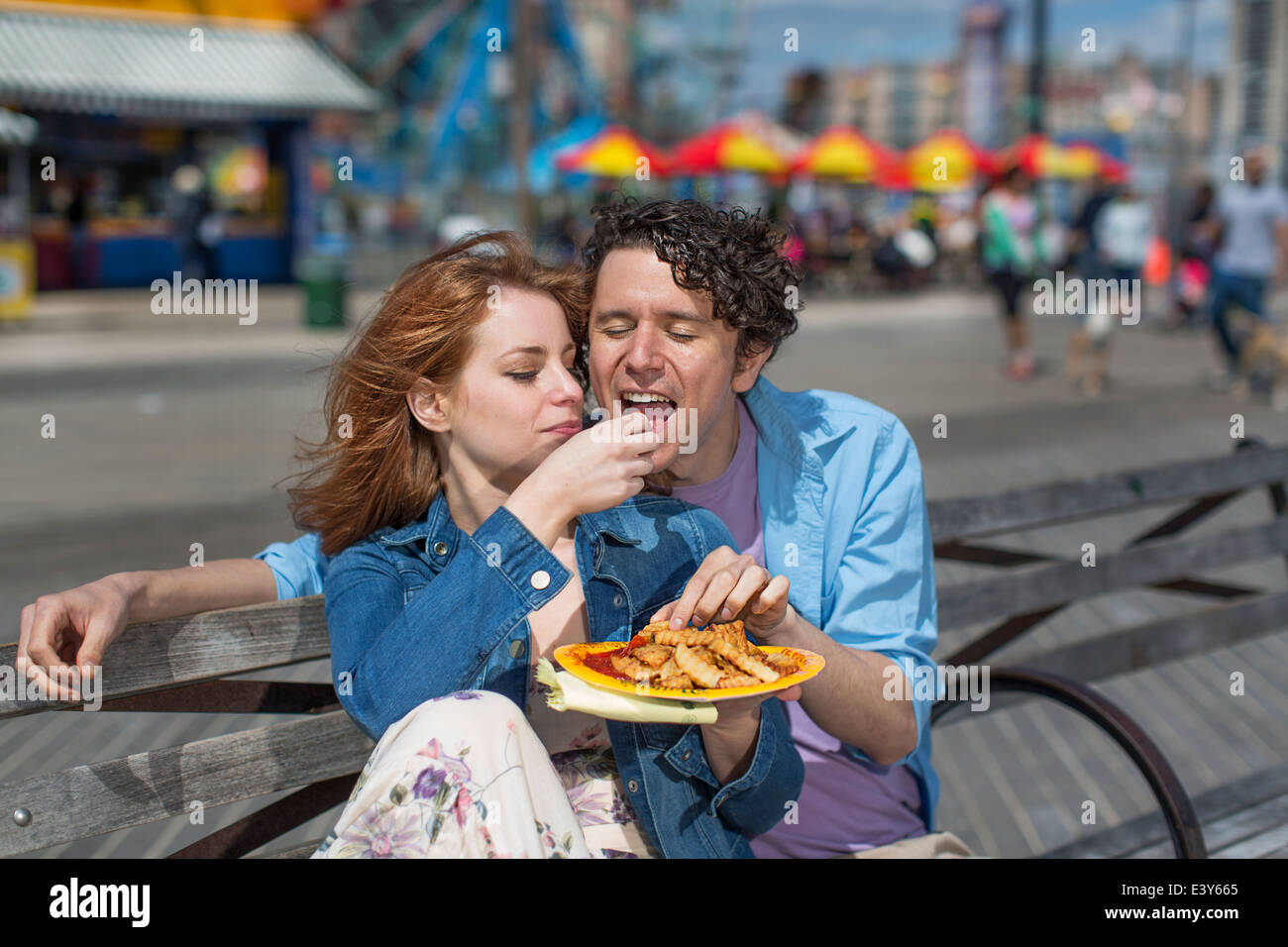 Romantisch zu zweit essen Chips im Freizeitpark Stockfoto