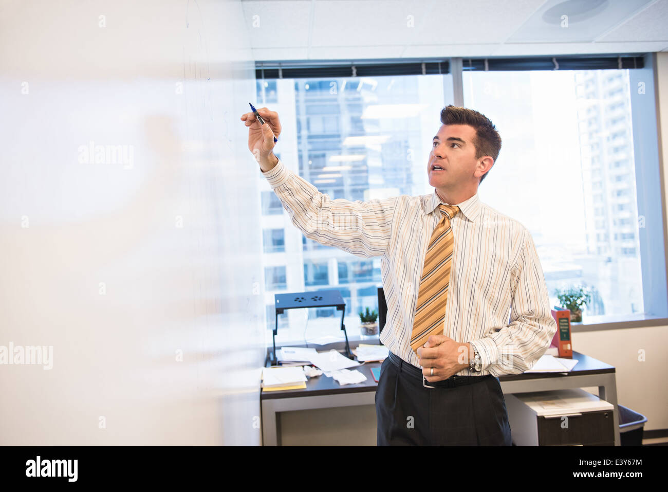 Wirtschaftsjurist schreibt am Whiteboard im Büro Stockfoto