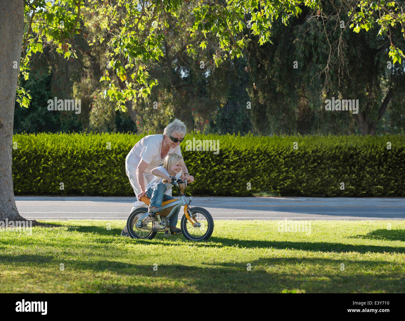 Drei Jahre alter Junge mit Großmutter im Park fahren lernen Stockfoto