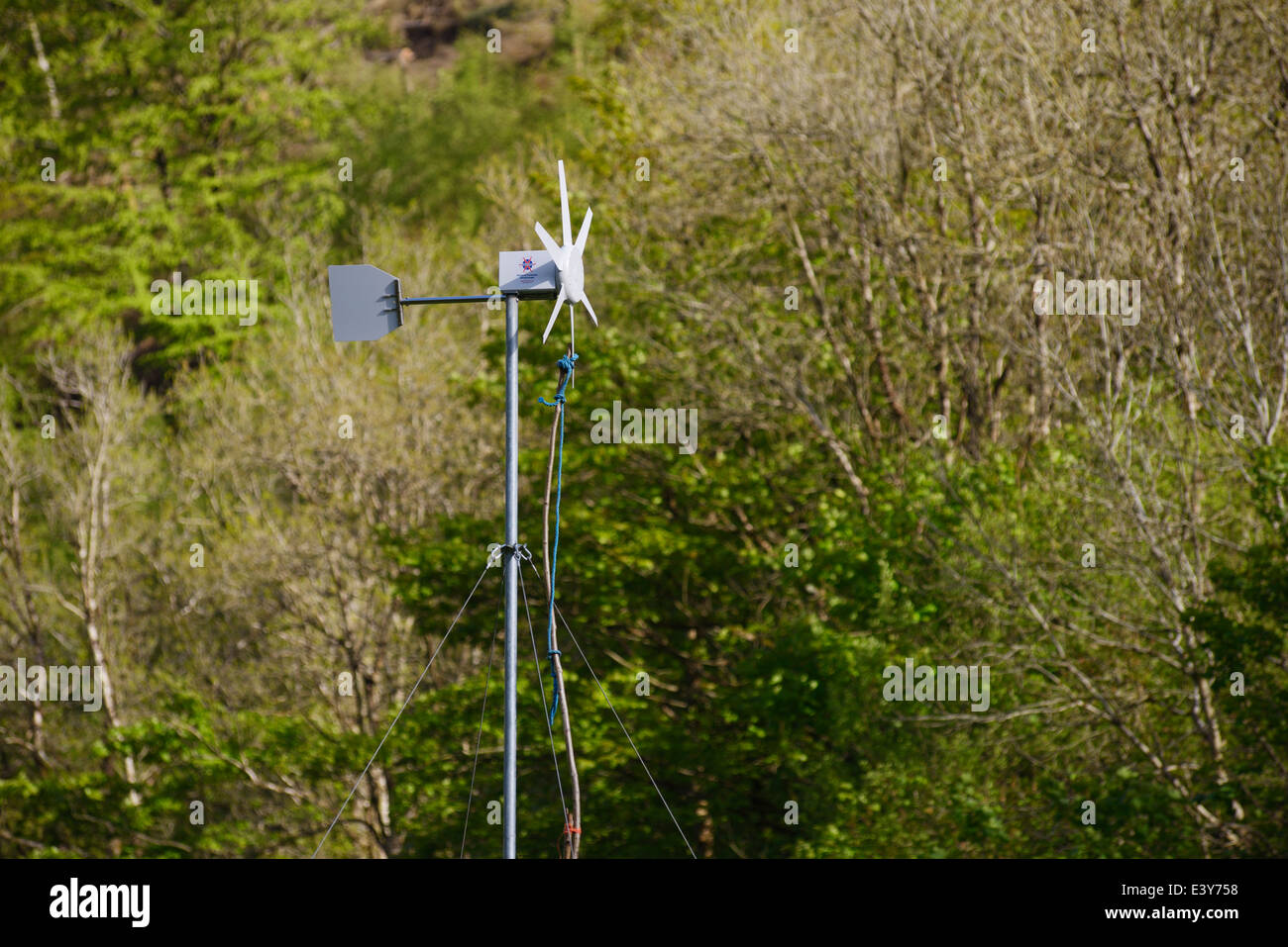 Kleine Windkraftanlage, gesichert mit einem Stock und Seil für Wartung, Wales, Vereinigtes Königreich. Stockfoto