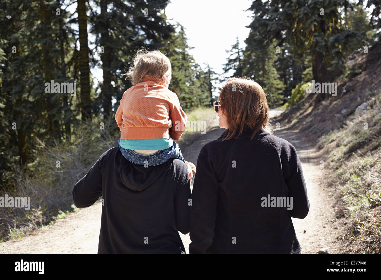 Frauen, die zu Fuß durch Wald in Oregon, USA, mit Kleinkind auf Schultern sitzen Stockfoto