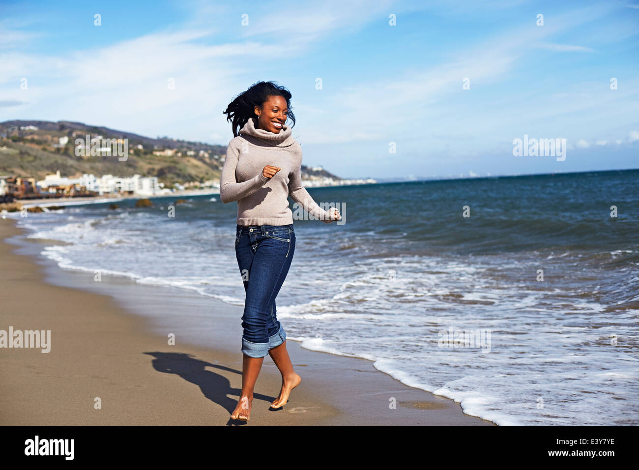 Junge Frau barfuß am Strand von Malibu, Kalifornien, USA Stockfoto