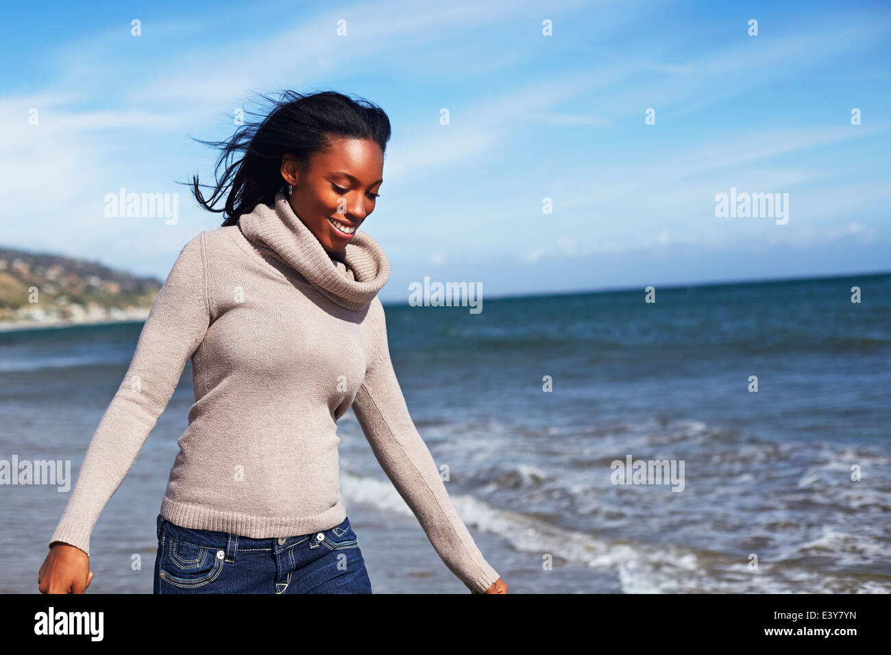 Junge Frau, die zu Fuß am Strand von Malibu, Kalifornien, USA Stockfoto