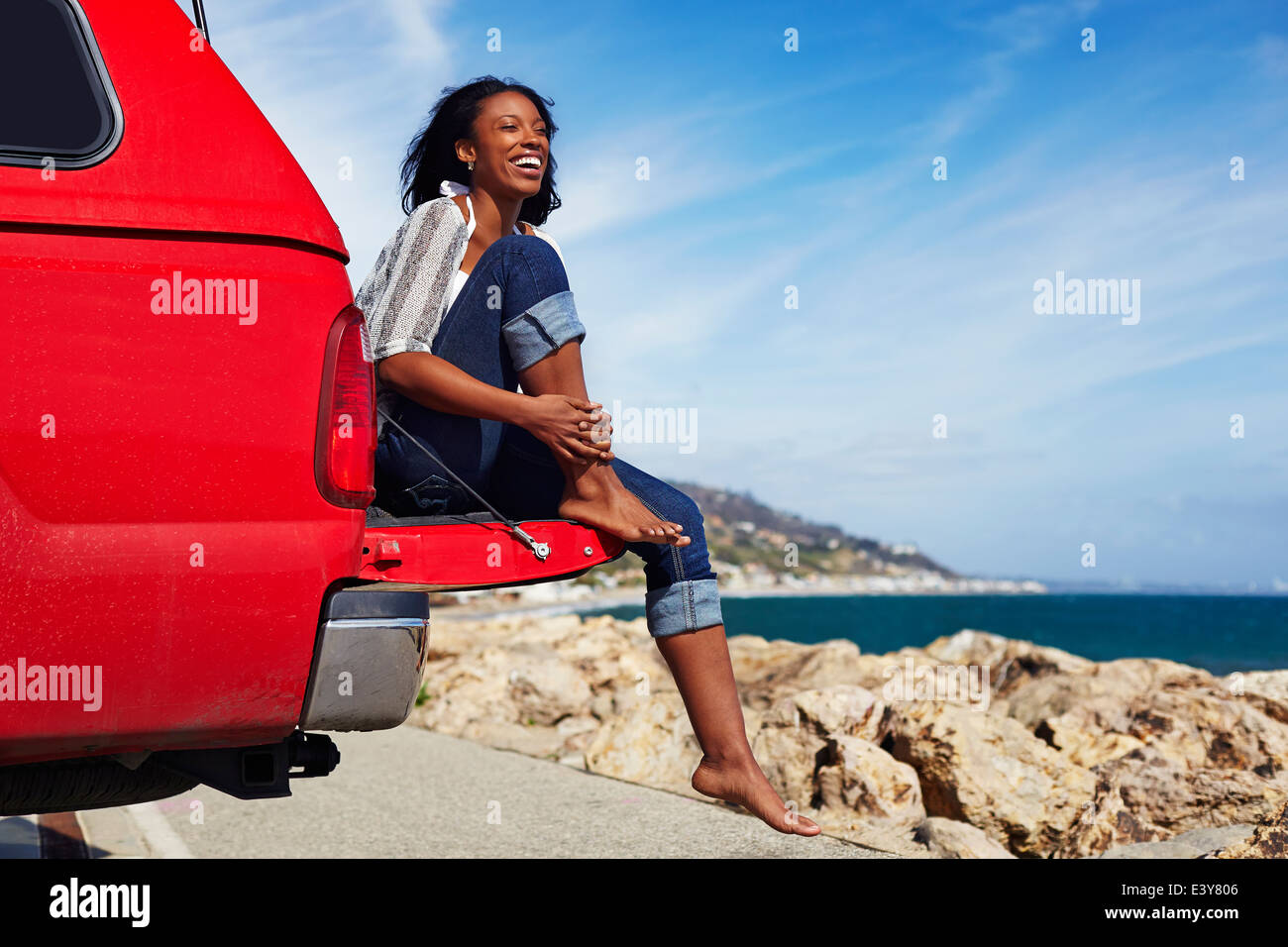 Junge Frau sitzt auf der Motorhaube, Malibu, Kalifornien, USA Stockfoto