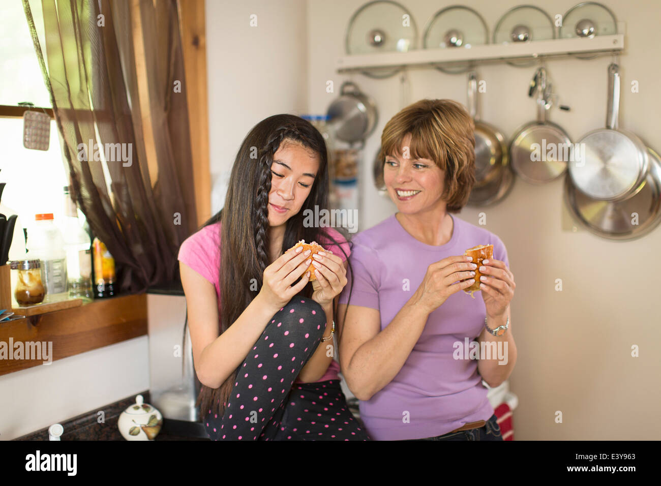 Mitte Erwachsene Frau und Teenager-Mädchen in Küche, Essen snack Stockfoto