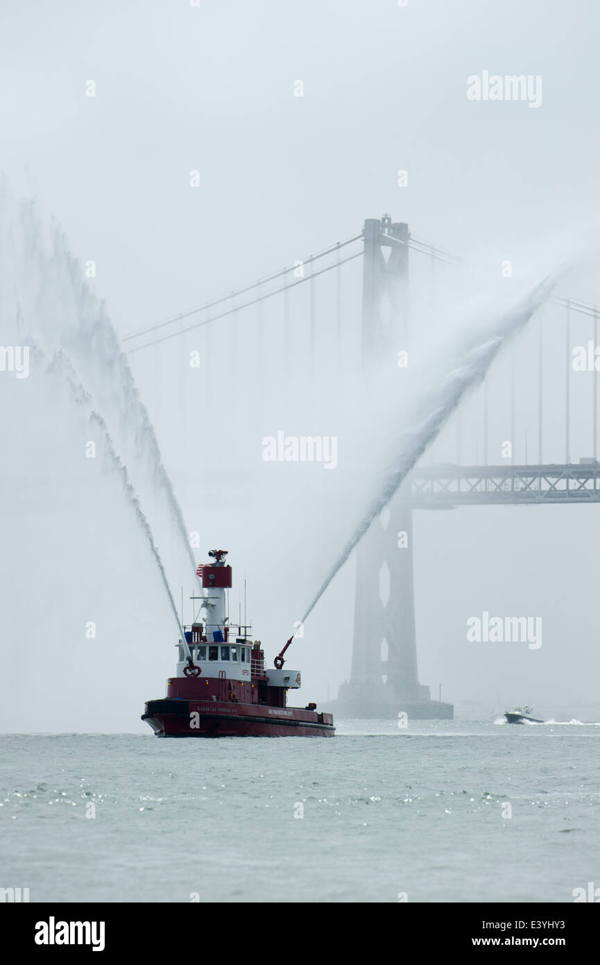 San Francisco Feuer Boot sprüht Wasser in der Bucht mit der Golden Gate Bridge in den Boden zurück. Stockfoto